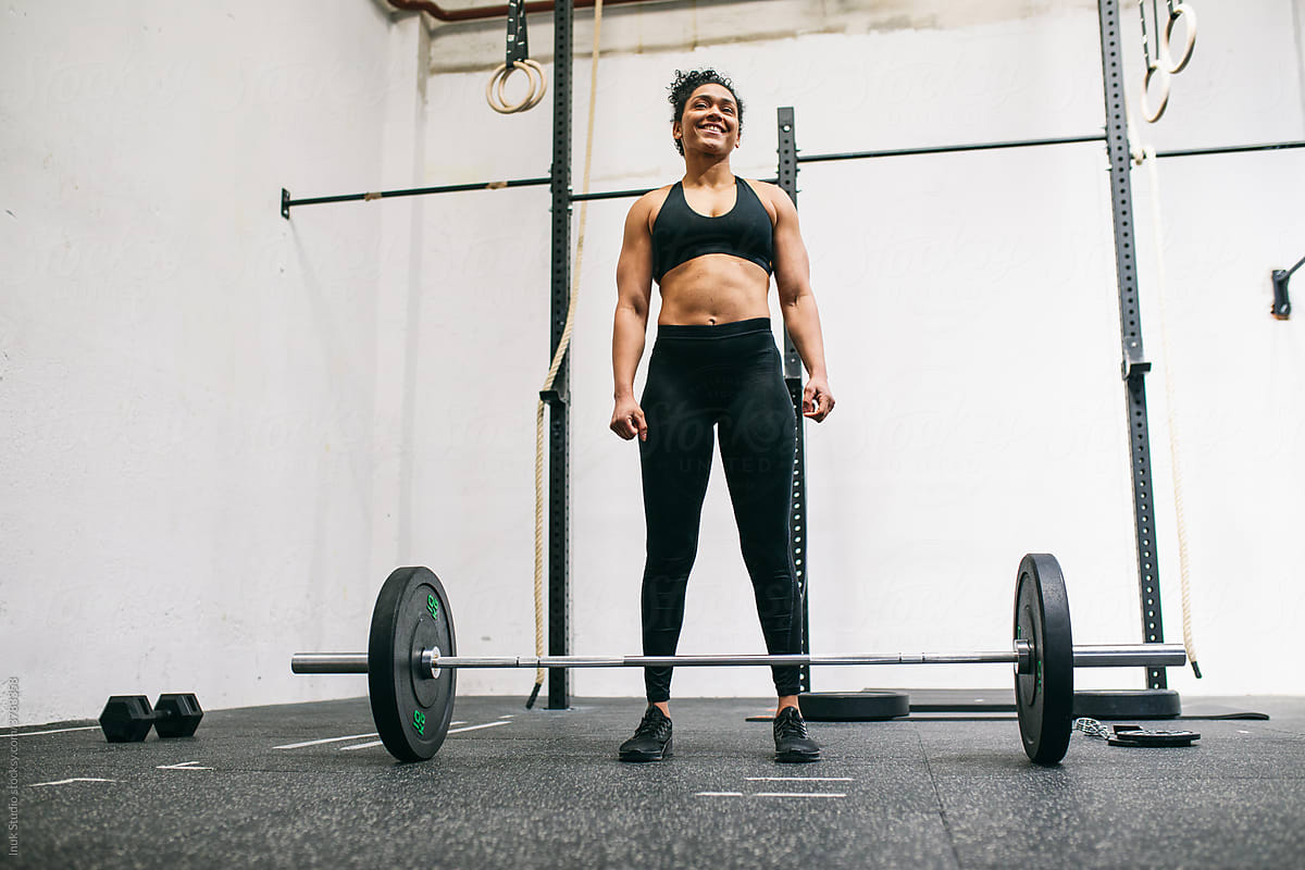 Muscular female athlete preparing to lift barbell
