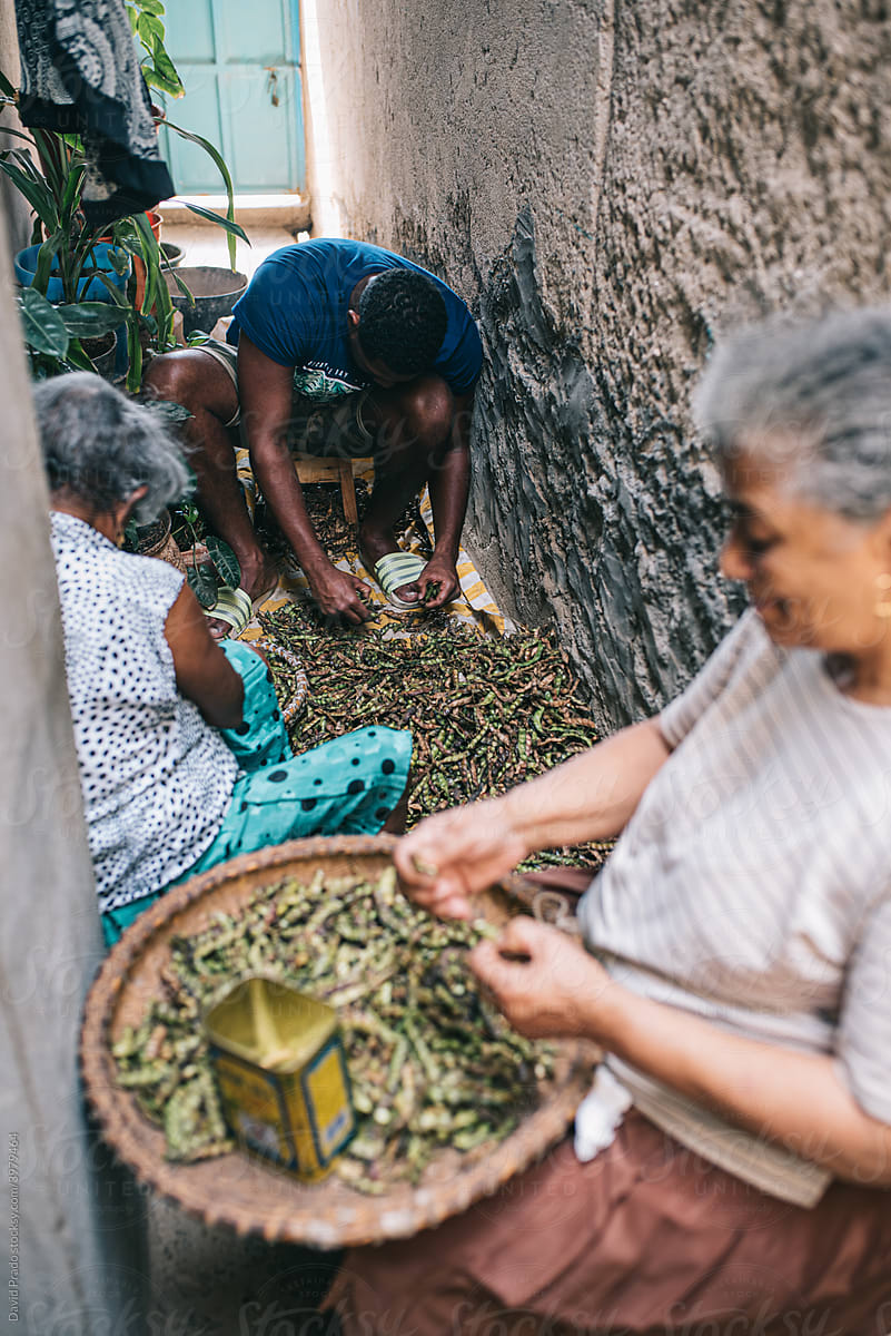 Ethnic people shelling beans together