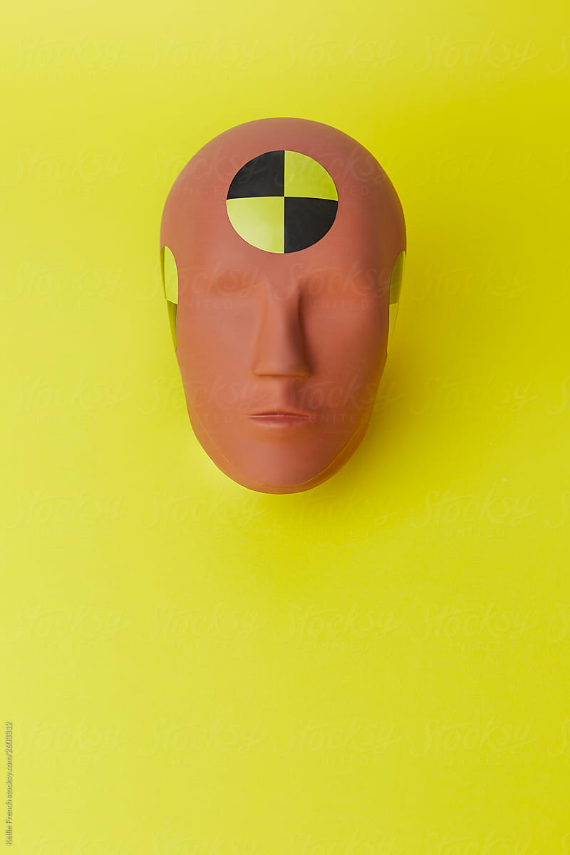 Crash test dummy head on yellow background