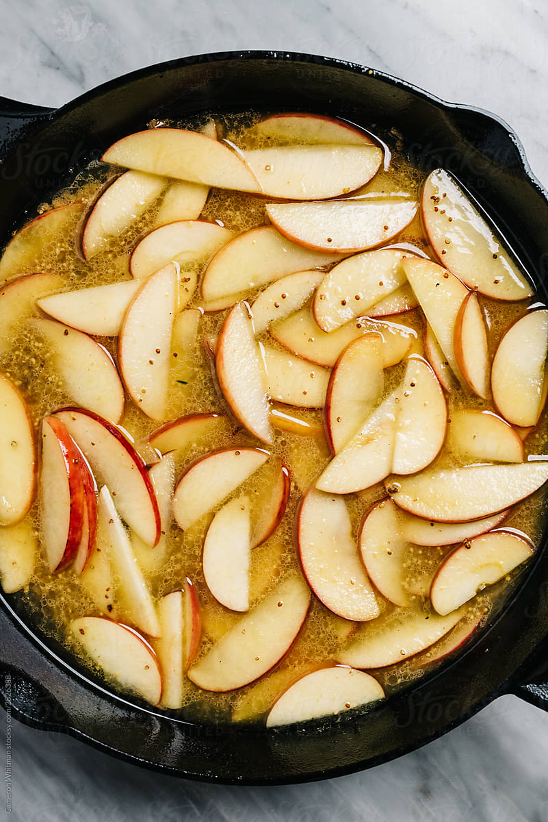 Cooking down apples in cider in an iron skillet