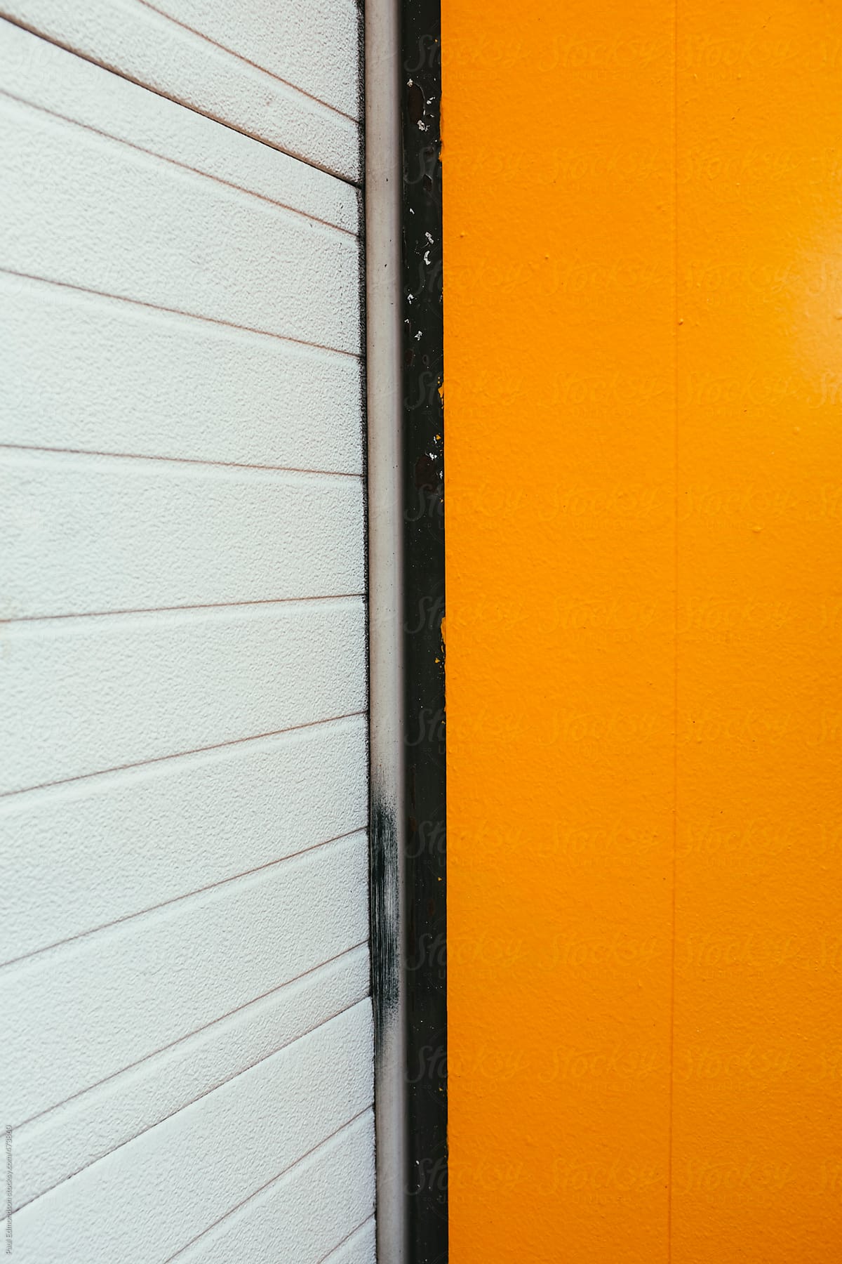 Detail of orange building wall and garage door