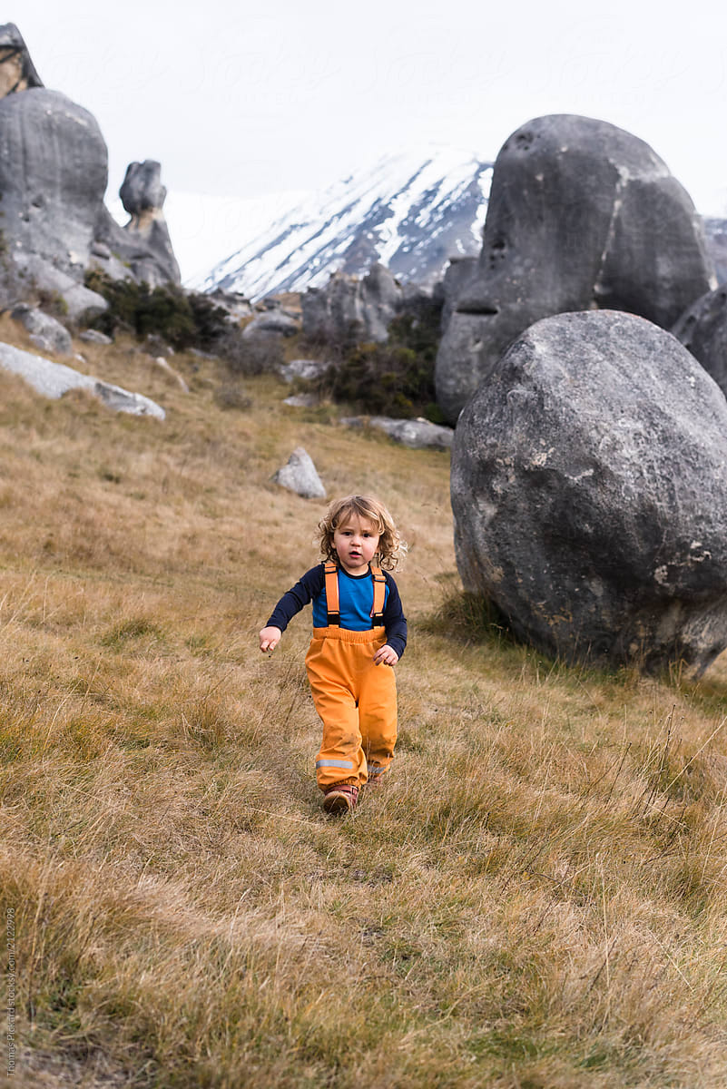 Young boy exploring limestone boulders, New Zealand.