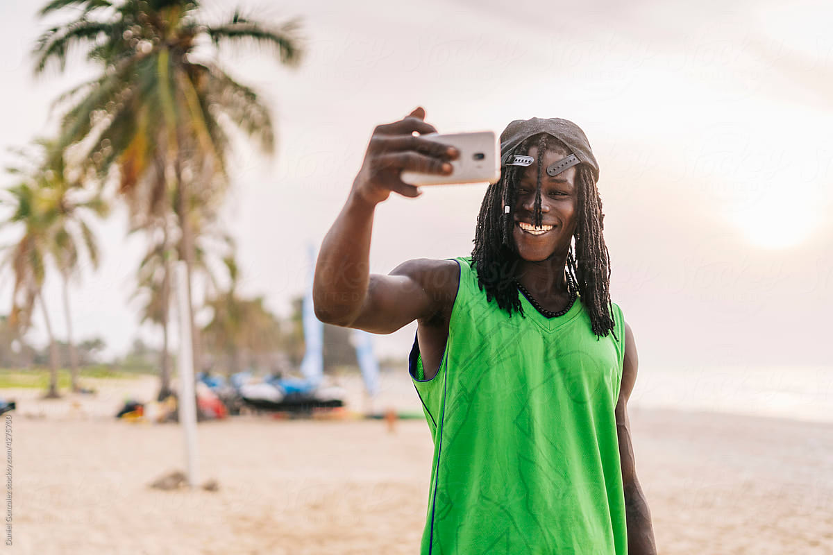 Cool guy shooting selfie on beach