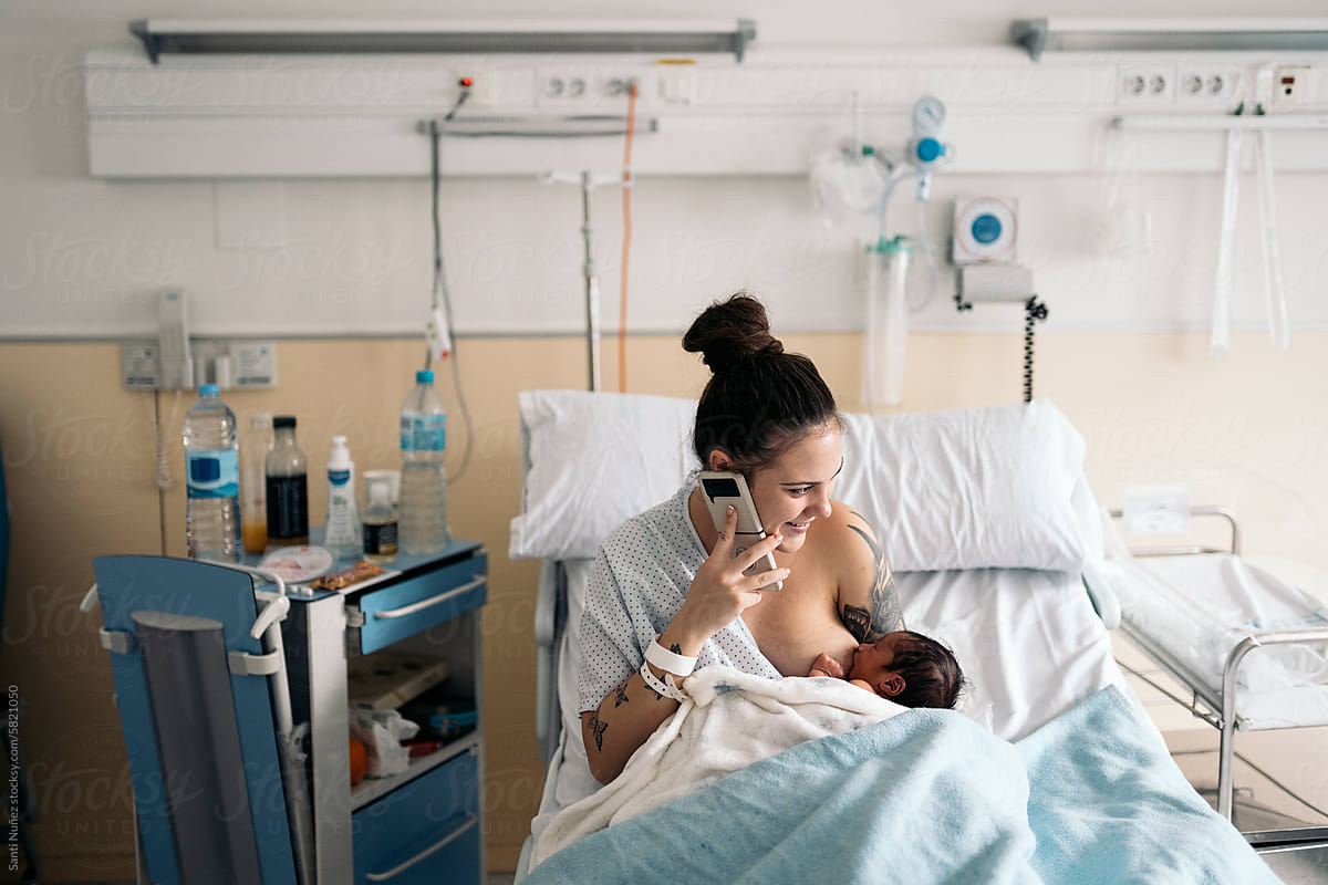 Mother Breastfeeding Newborn In Hospital room