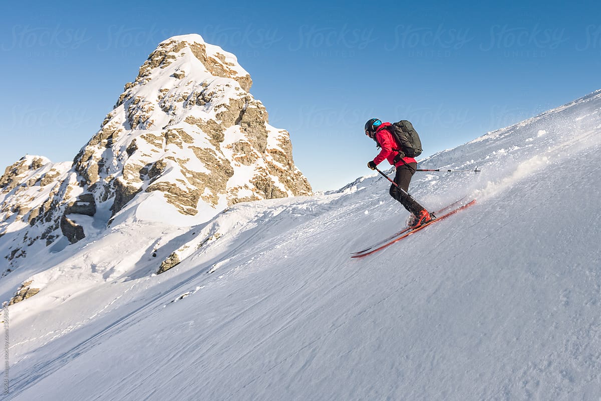 Skier Sliding Down On Steep Snow Slope by Stocksy Contributor Ibex.media  - Stocksy