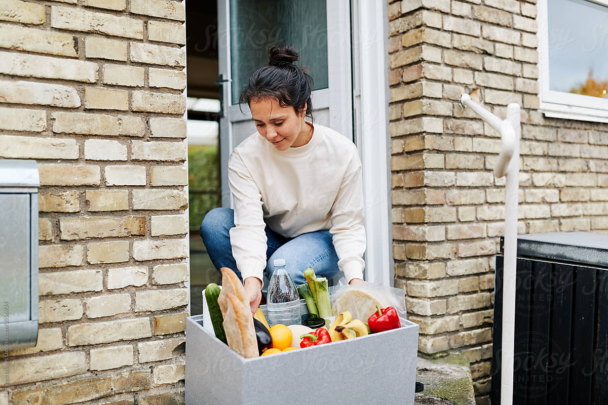 Woman picking up a food delivery at her door