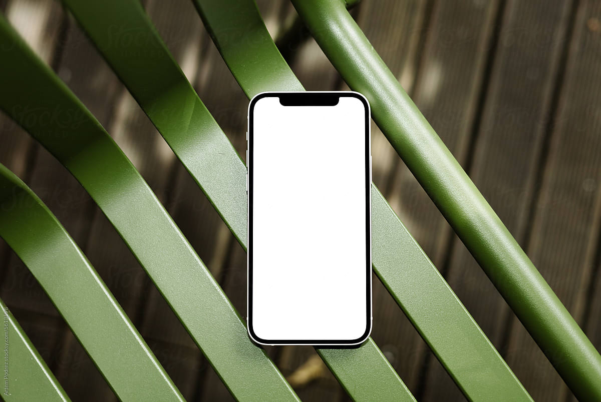 A mock-up of a mobile phone with a white screen on a green chair