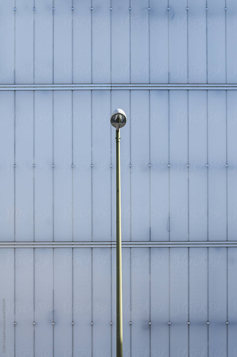 Street lamp near building with geometric lines.