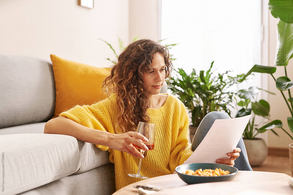 Businesswoman reading documents during lunch at home