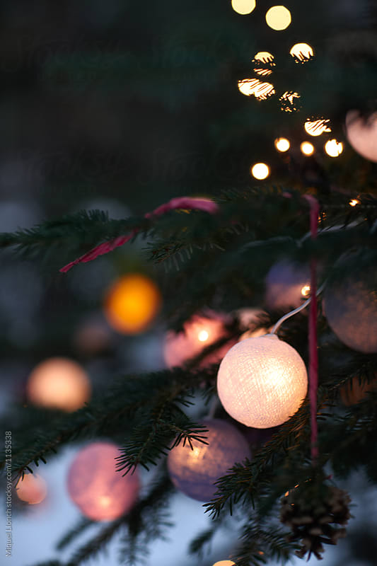 Close up of Christmas tree wiht lit balls and ornaments outdoors