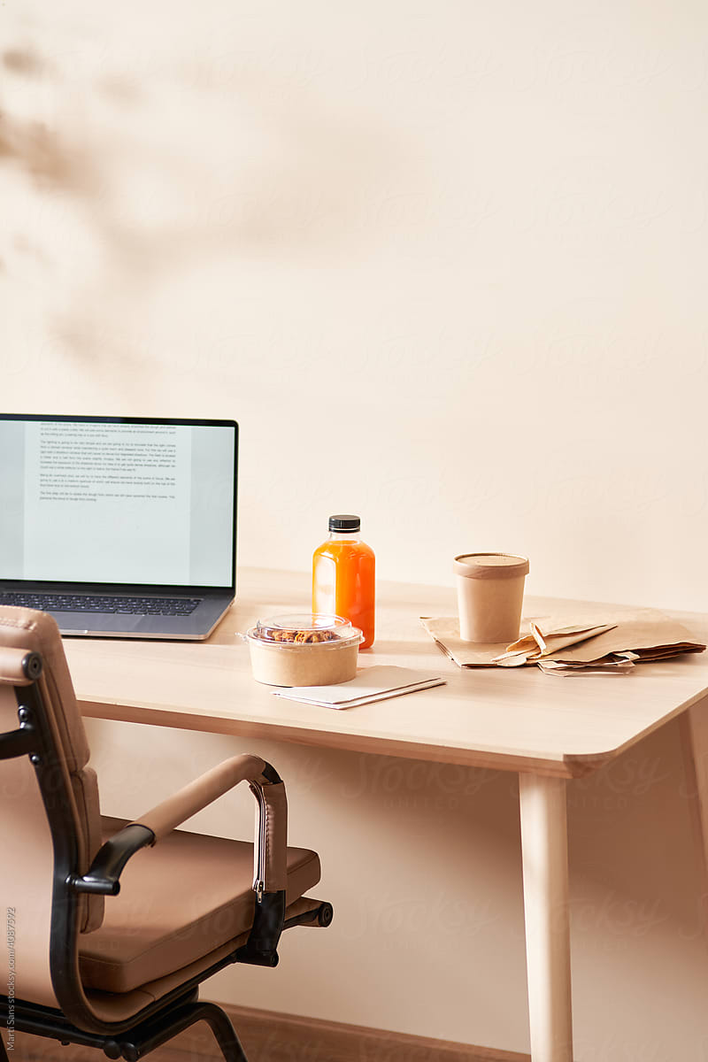 Takeaway food and netbook on desk