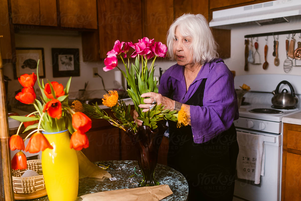 Hoary elder woman making flower vases at home