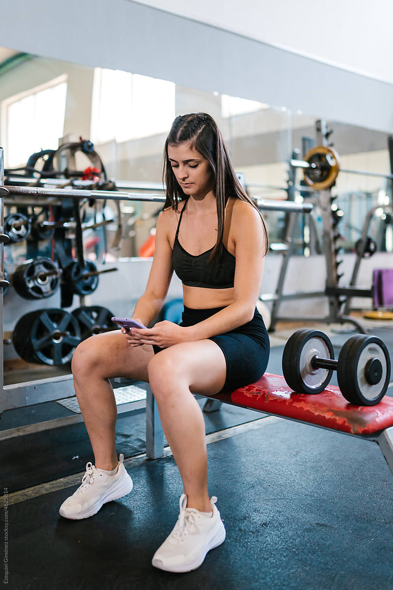 Athlete using smartphone during weightlifting workout