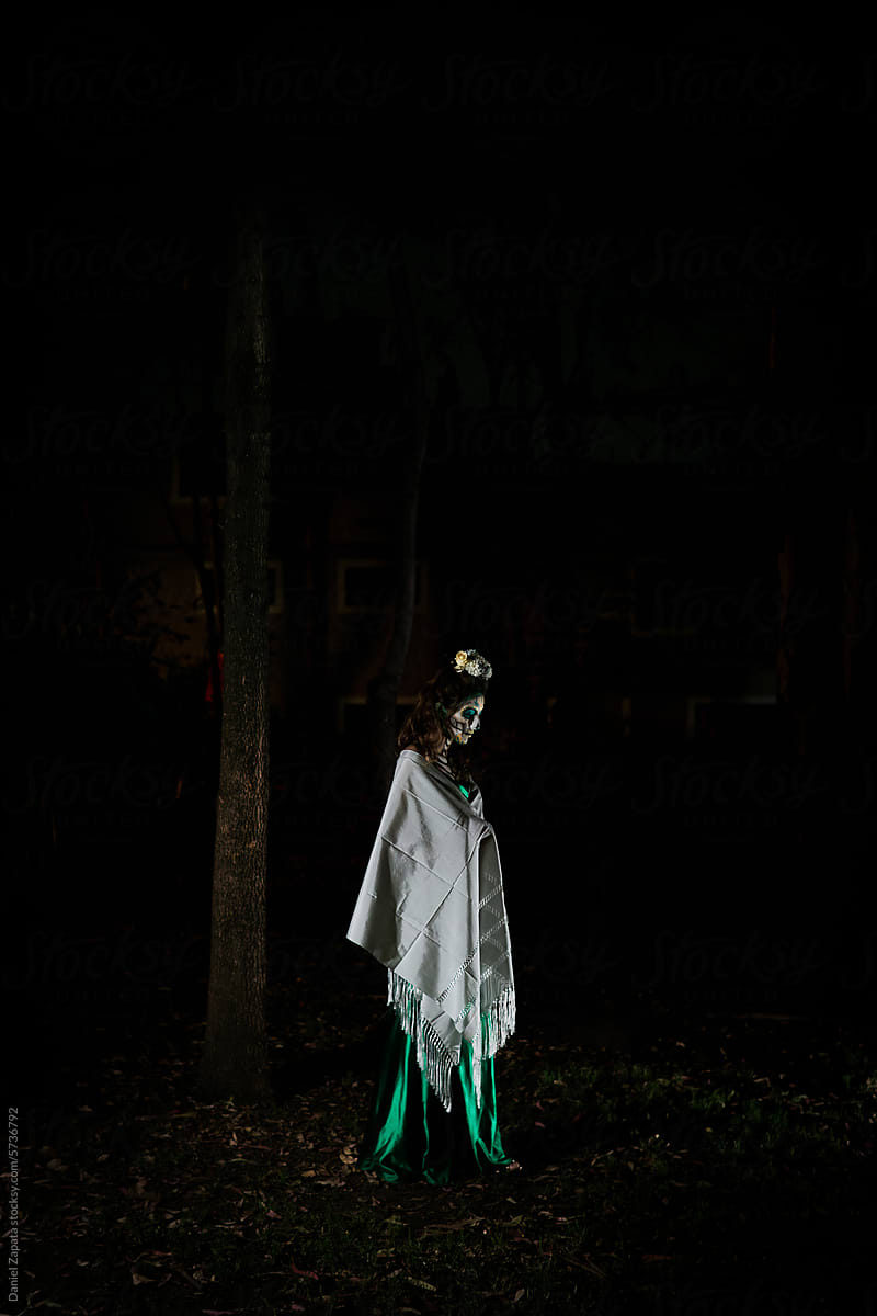Woman in the forest characterized as a catrina.
