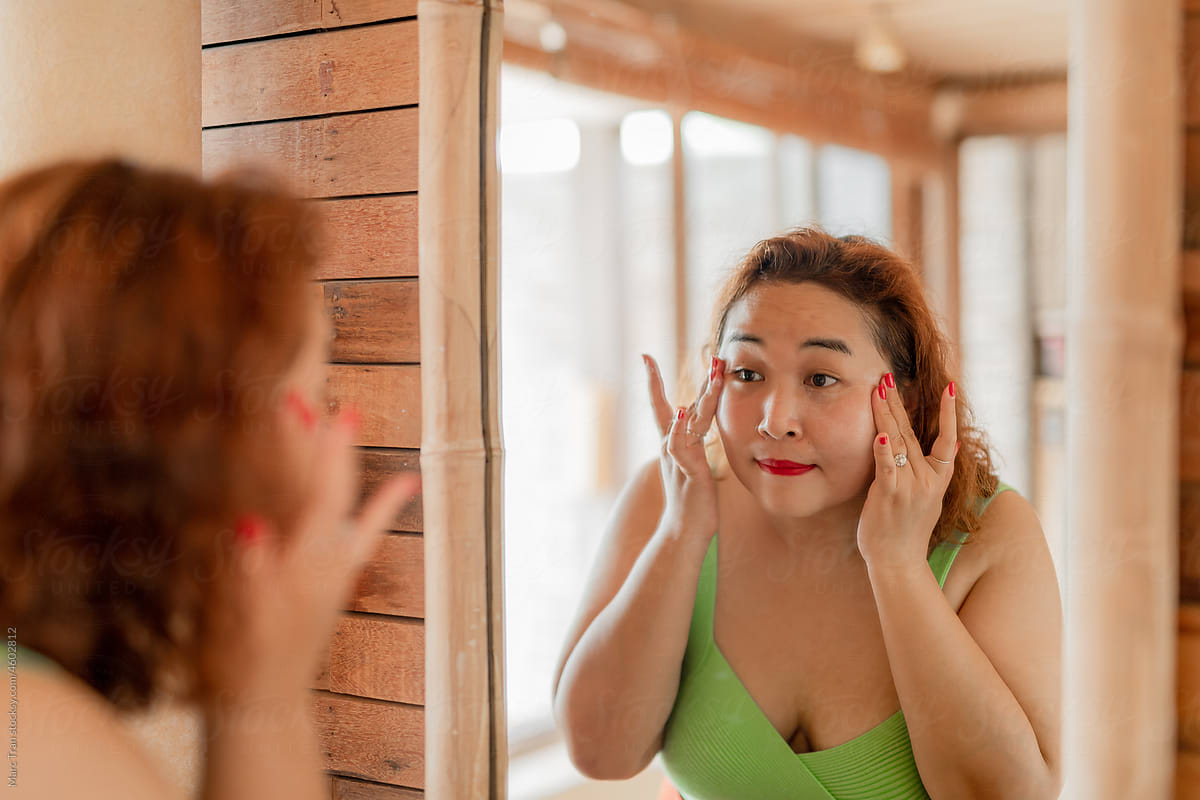 Asian women applying face lotion.