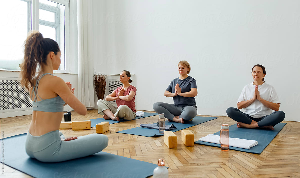 Group of women meditating together with instructor