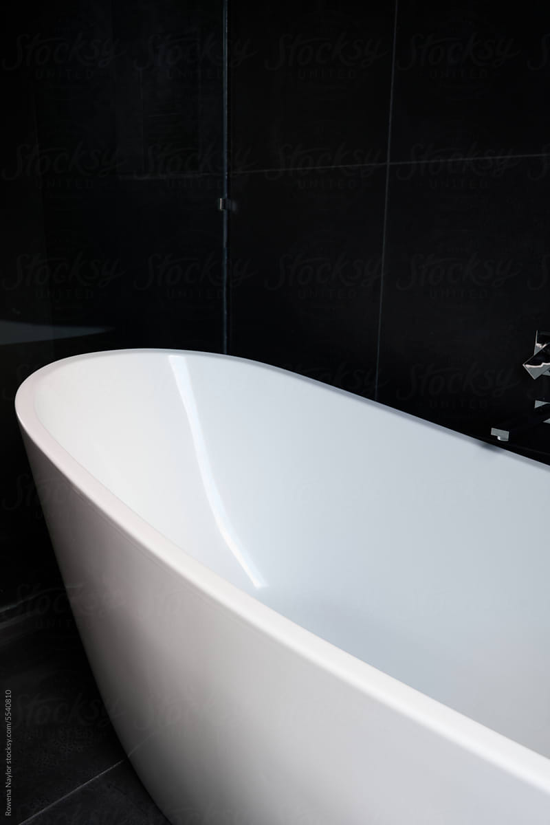 Bathtub against black tiles