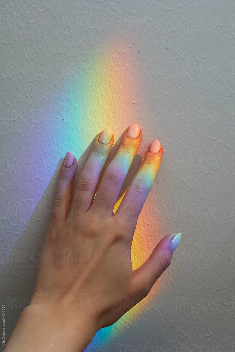 A hand with a rainbow reflection