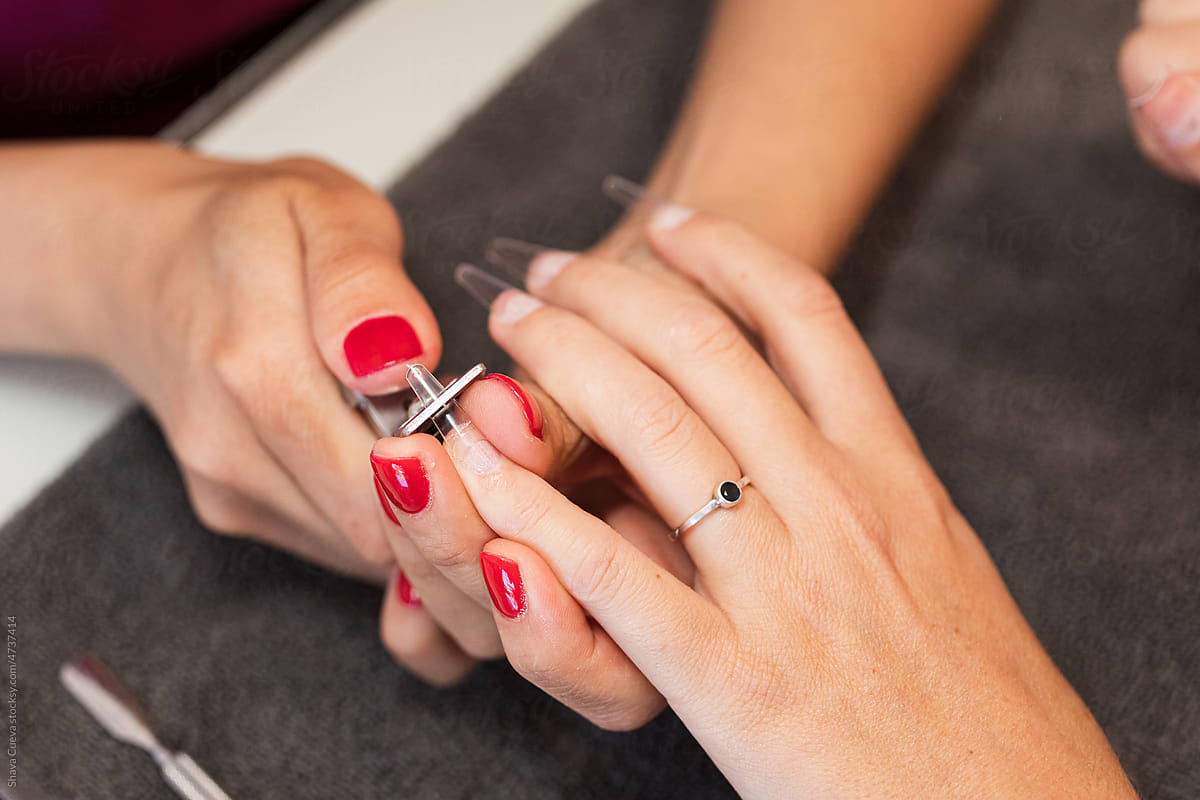 beautician's hands cutting nails of a woman