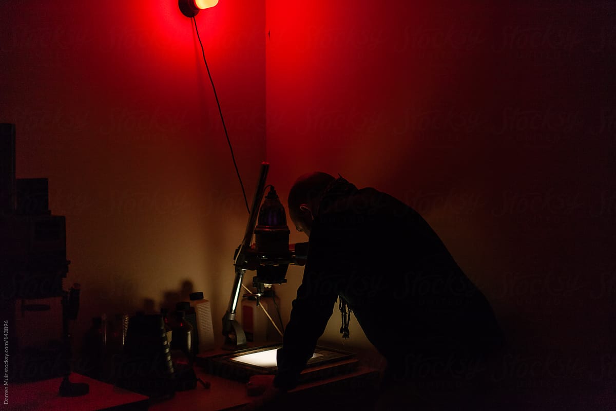Man working in darkroom.