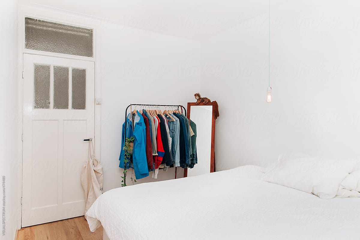 White Minimalist Bedroom With Male Clothes on Clothing Rail
