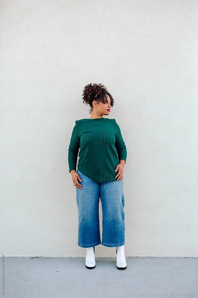 Curvy woman in green shirt, jeans and boots
