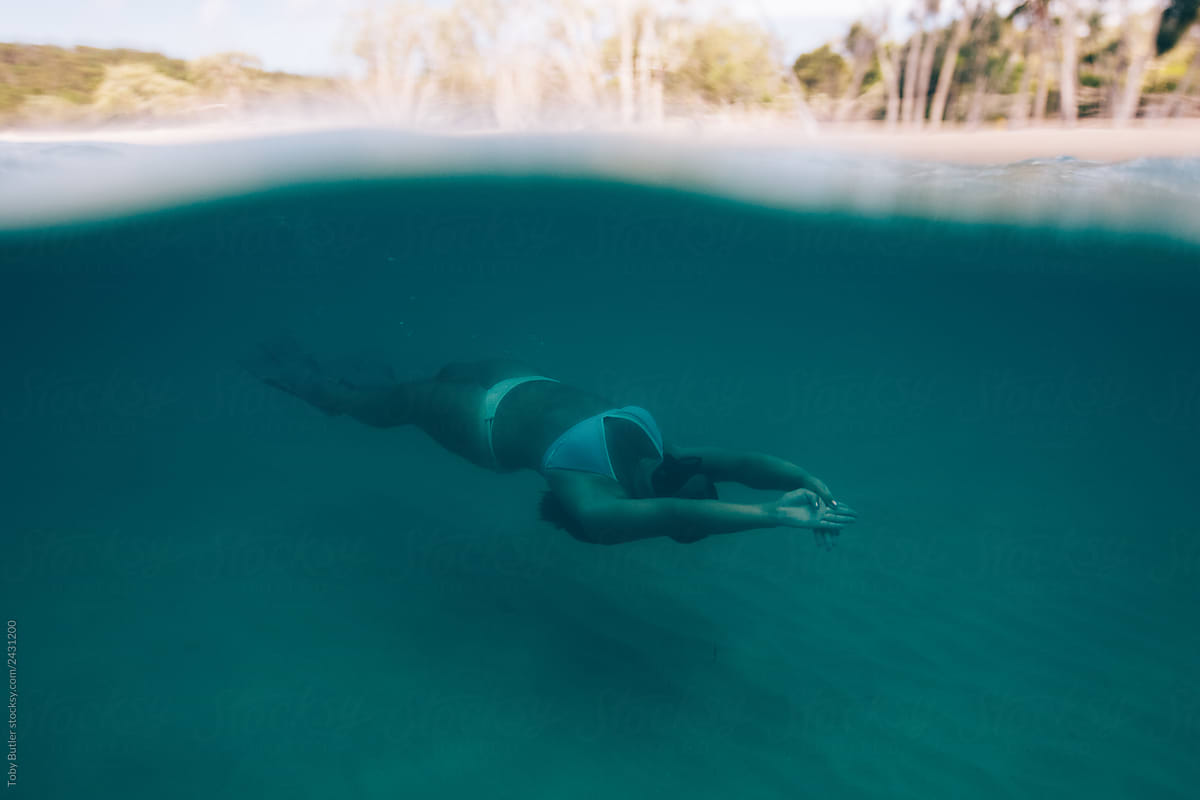 A girl swims freely in colourful water