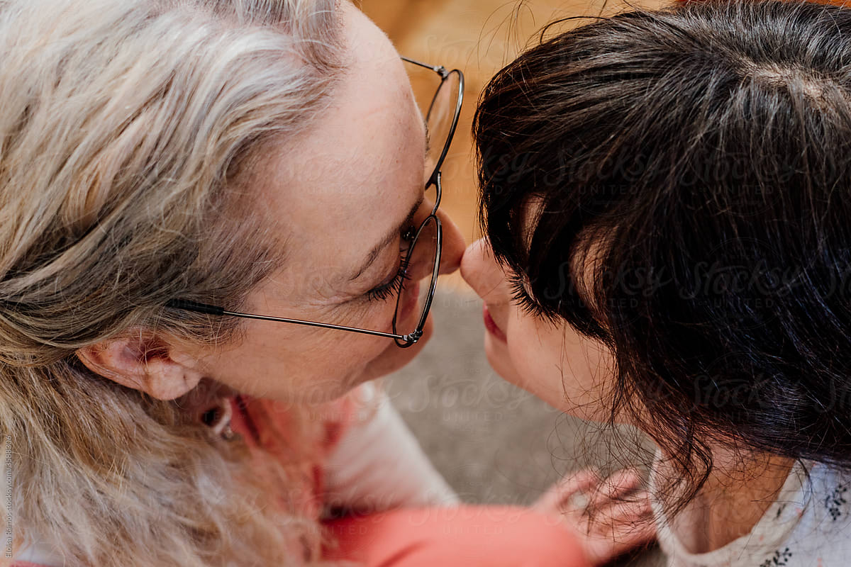 Portrait of grandmother and granddaughter looking each other with tenderness