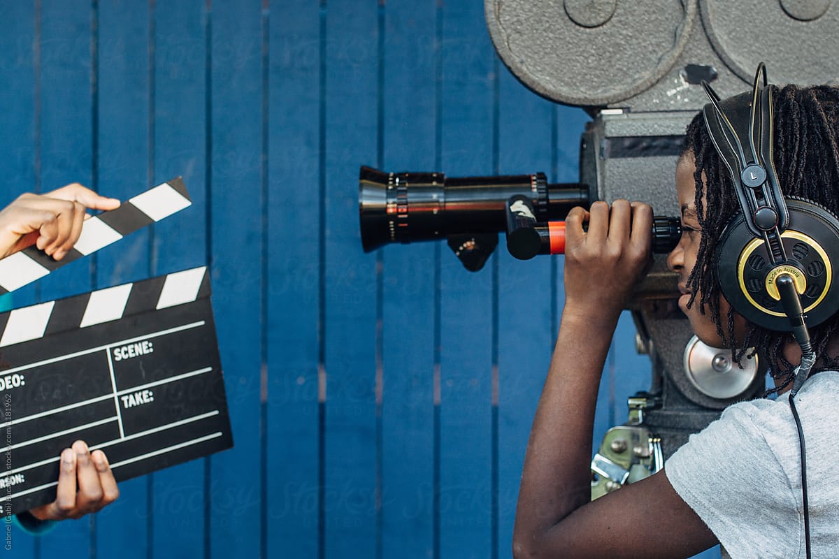 Black girl filming with an old 16mm film camera