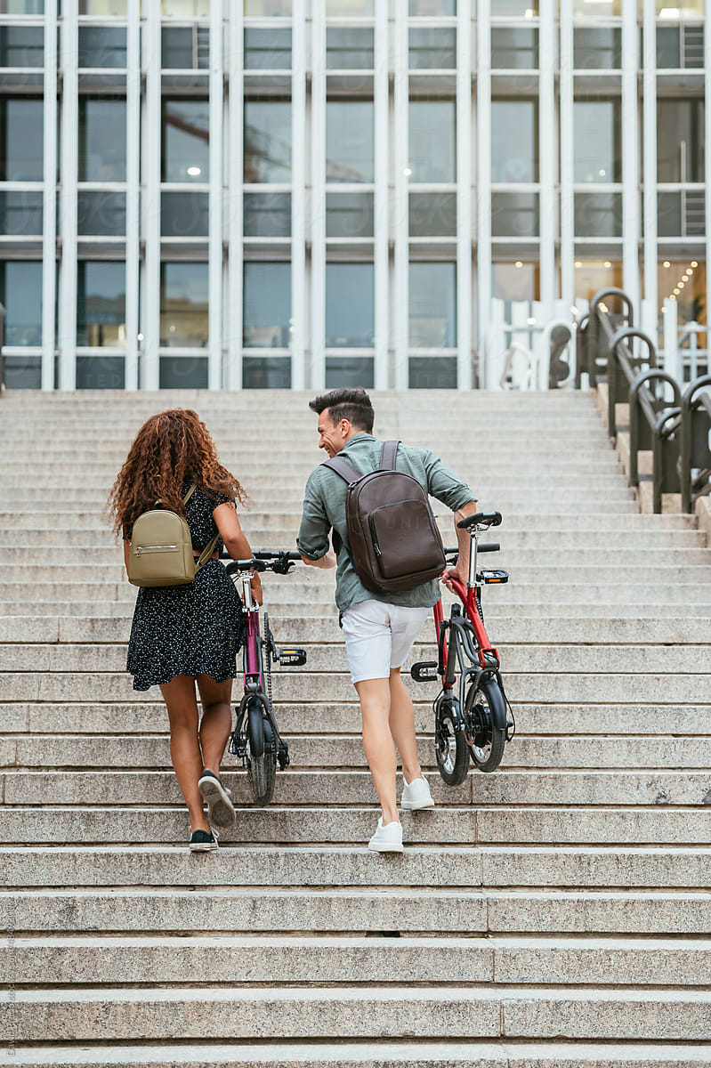 Diverse cyclists walking on steps