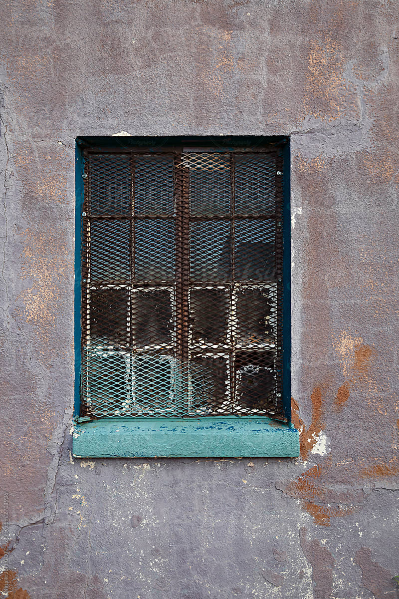 Close up of weathered purple building with old window