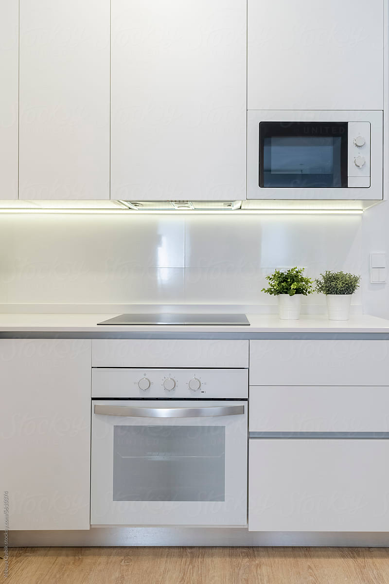 Modern kitchen with white cabinets, oven, microwave and ceramic hob