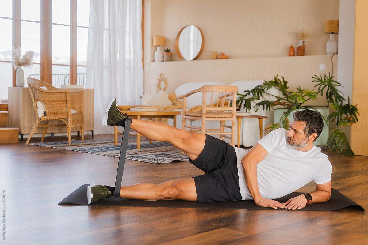 Senior Man With Grey Hair Doing Fitness Exercise At Home