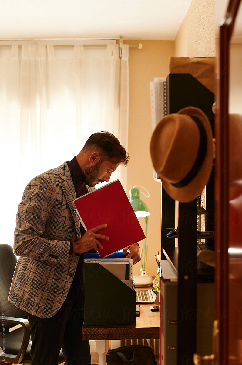 Businessman organizing paperwork in his office at home