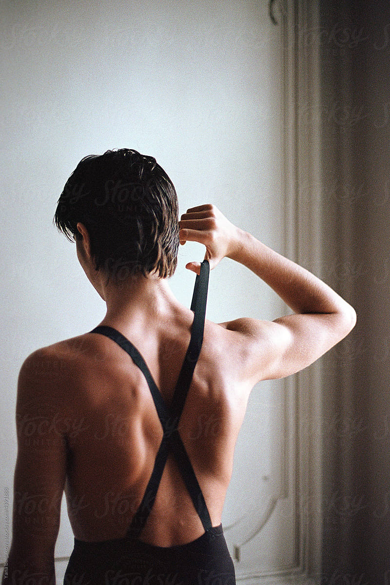 Topless young man holding suspenders