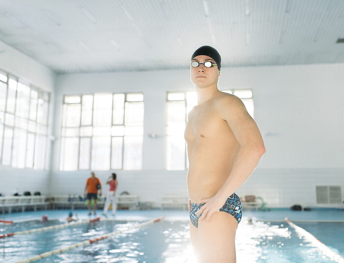 Young swimmer standing in sunny pool