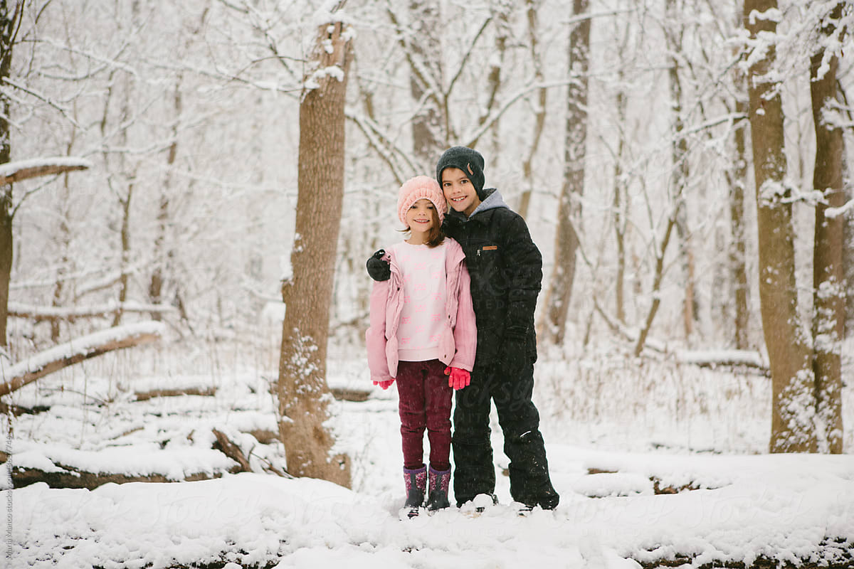 kids hug in snowy woods
