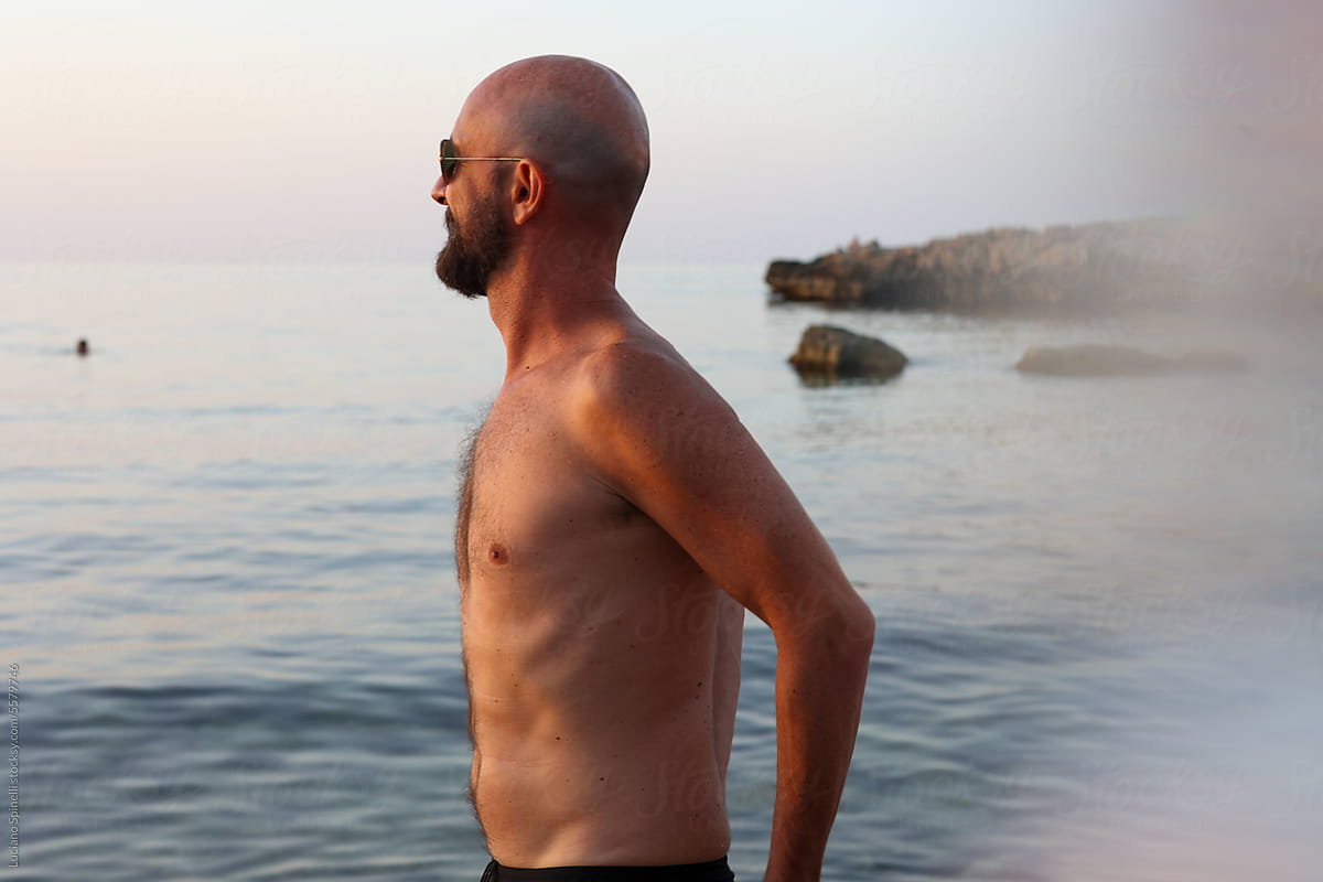 Athletic model in good shape contemplating the sea during his holiday