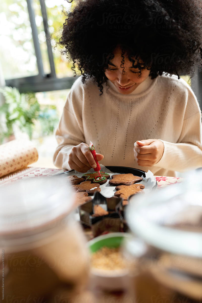 Afro woman decorating gingerbread