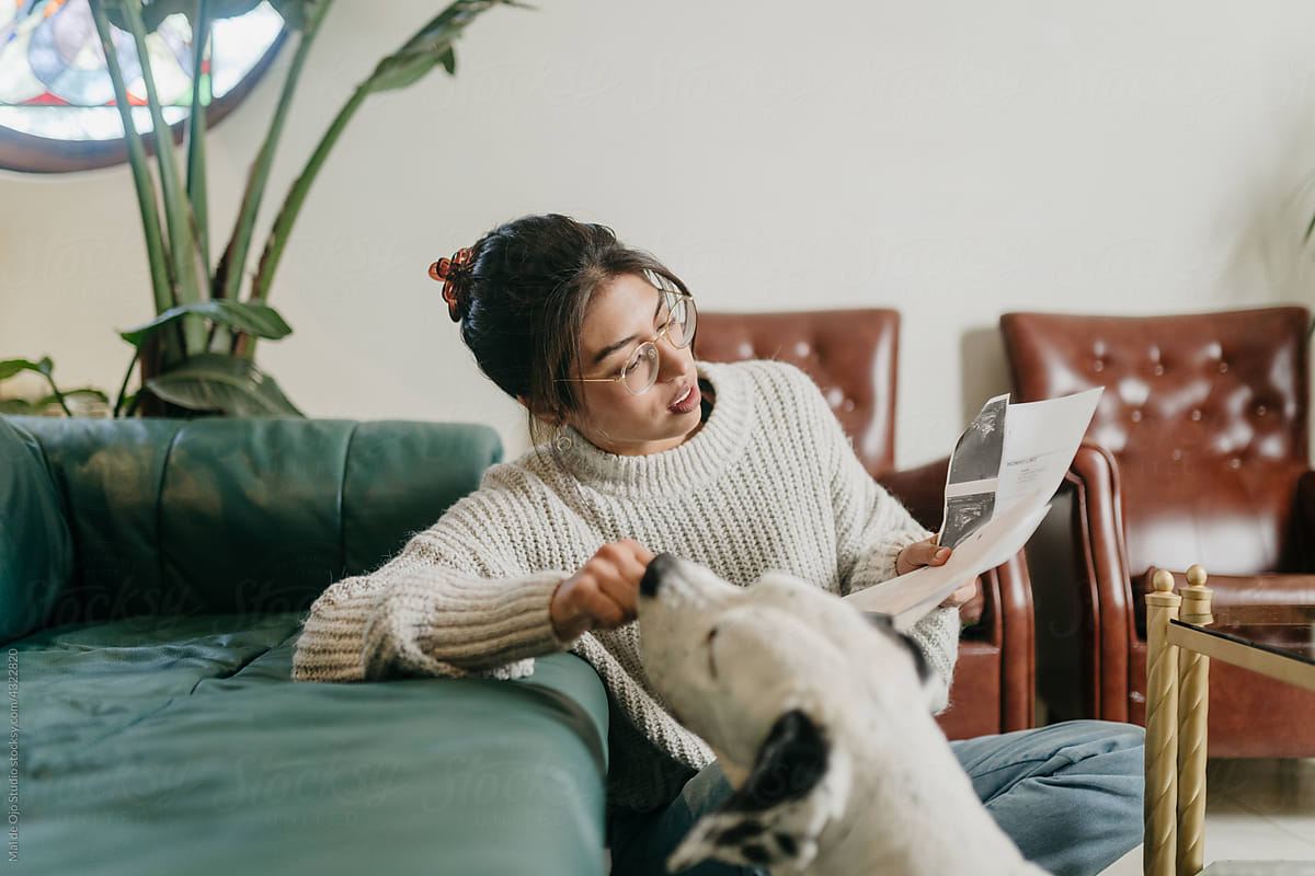 Reading woman giving treat to dog