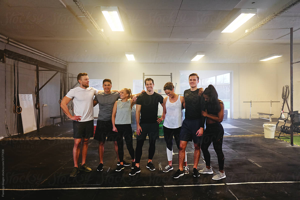 Smiling group of fit young people standing in a gym