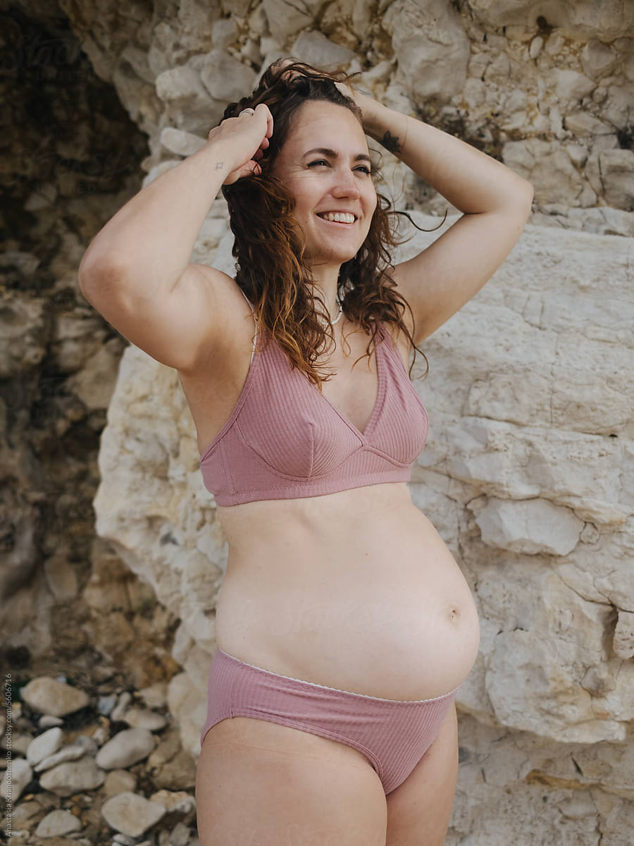 Pregnant Woman Wearing Underwear And Smiling In Front Of The Rock