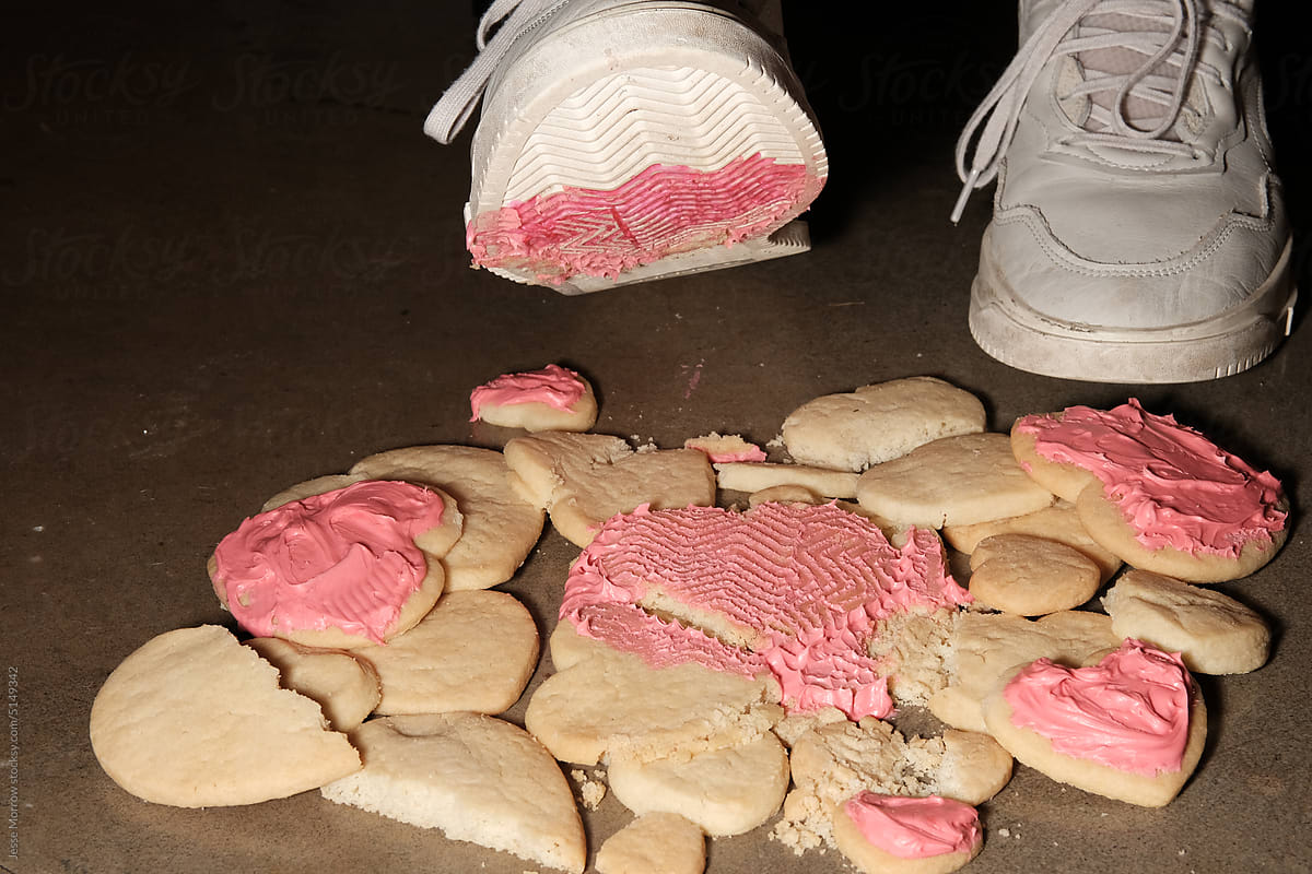 Foot standing over heart shaped Valentine\'s Day cookies