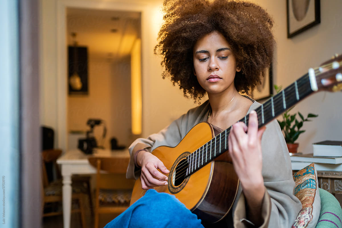Black Woman With The Acoustic Guitar Next To The Window At Home.