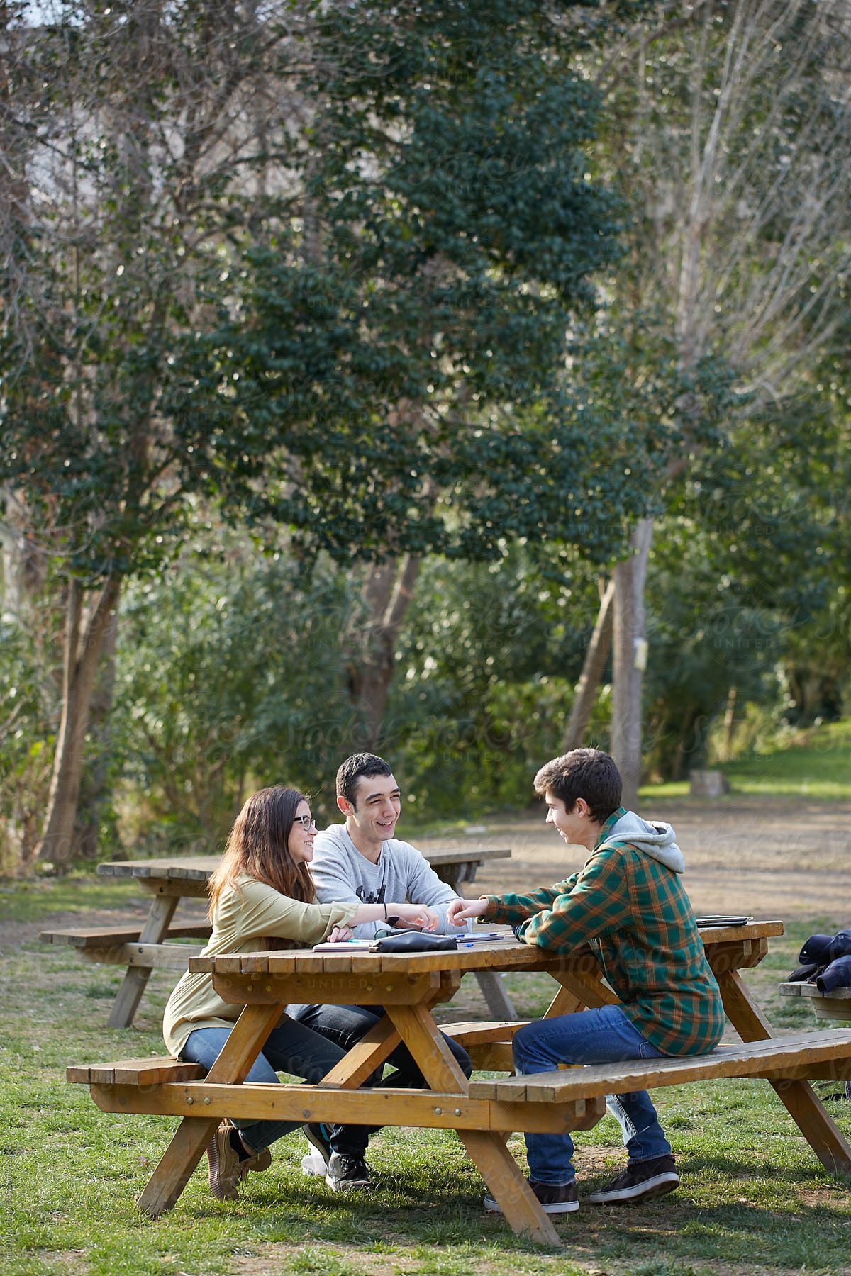 Group of three students in a relaxed moment in the campus