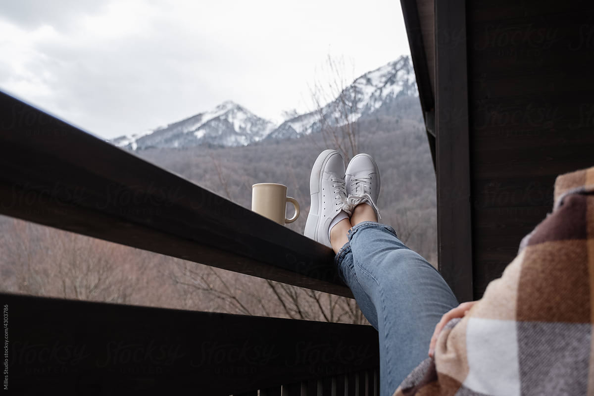 Anonymous woman relaxing on terrace in mountains