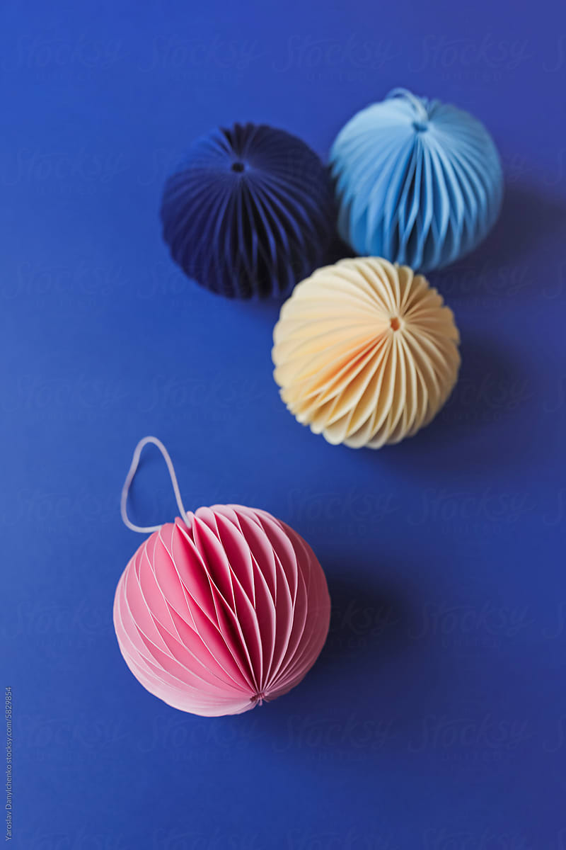 Balls decorations made in origami technique laying on blue background