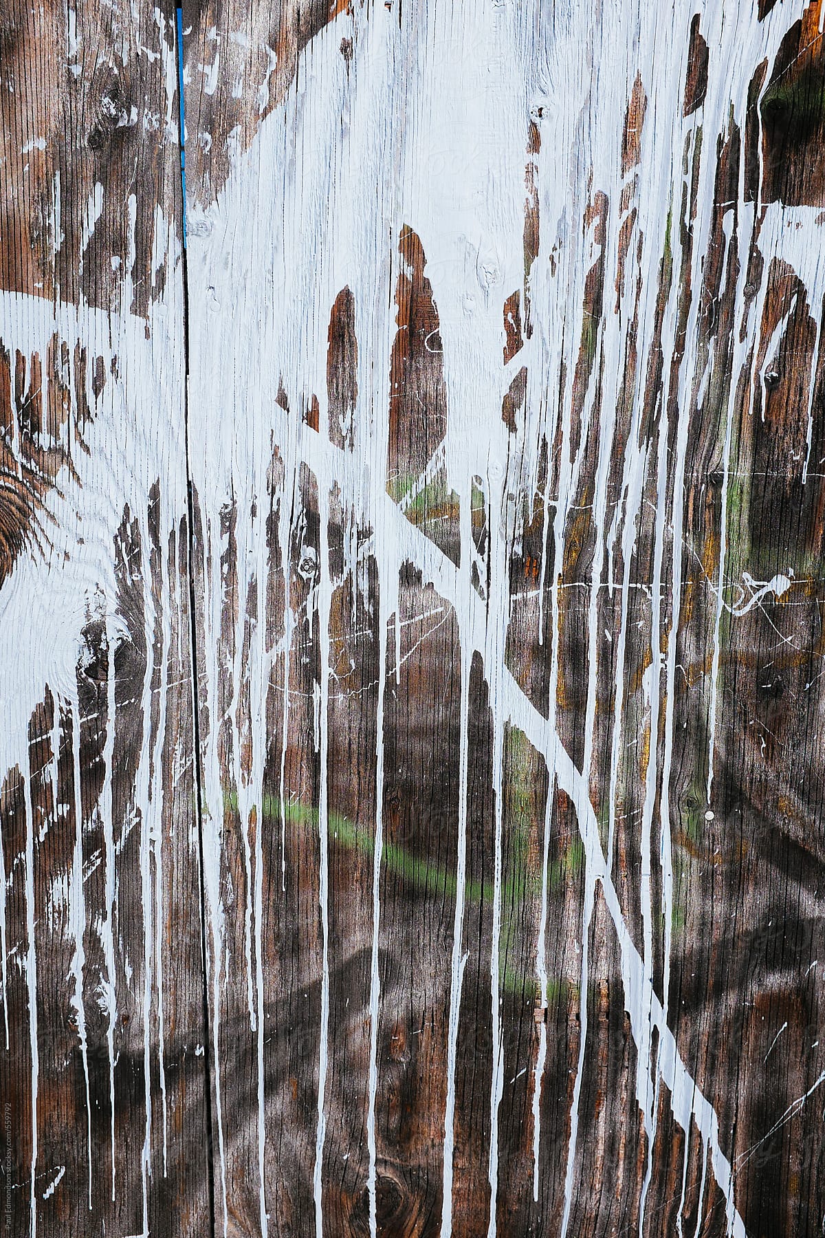 Paint splattered across worn plywood wall, close up