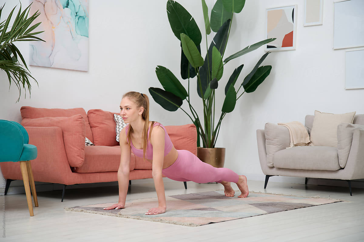 Fit woman doing plank exercise at home
