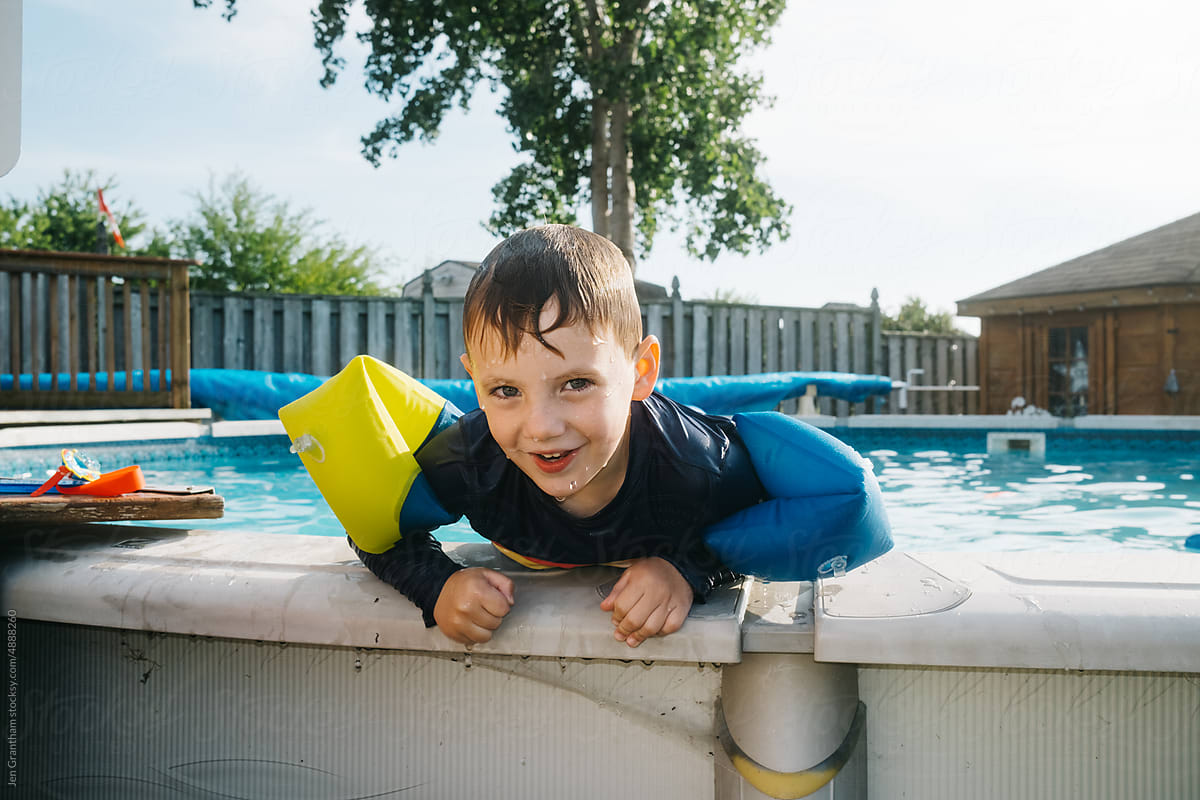 Boy swimming in pool with water wings